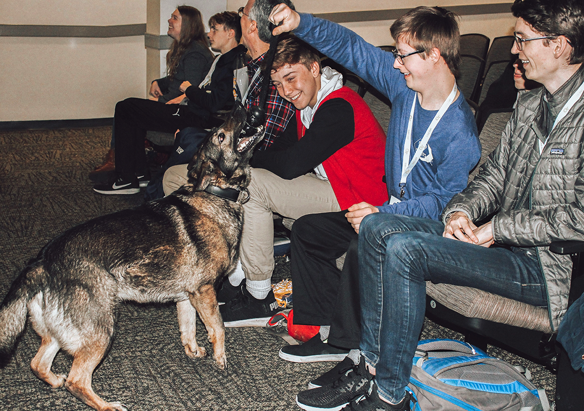 Brothers play with a dog at the GT auditorium.