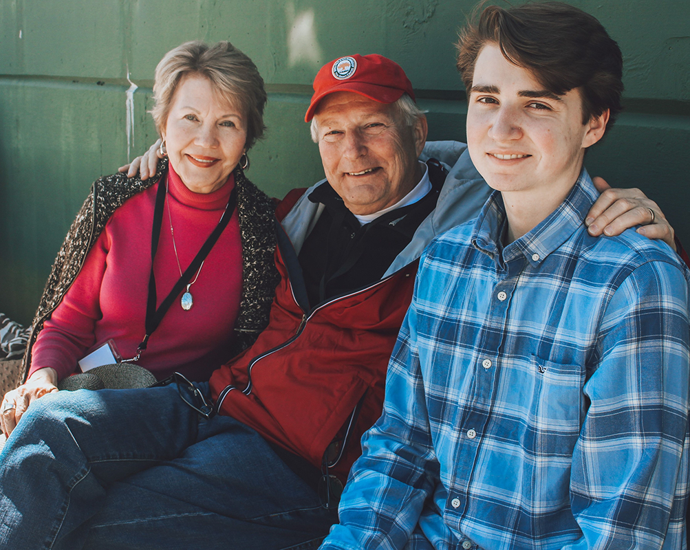 Grandparents and grandson at the baseball stadium.