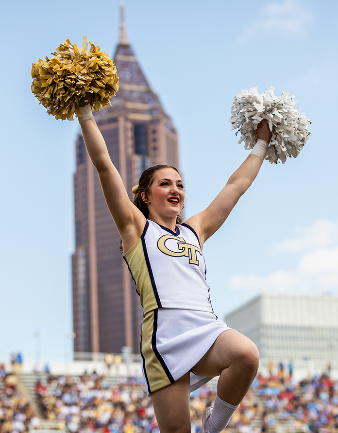 A female Georgia Tech cheerleader doing an extension stunt.