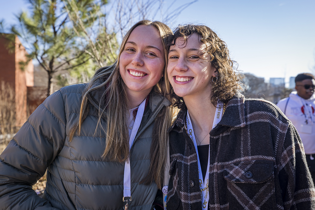 two young women with their heads touching, smiling towards the camera