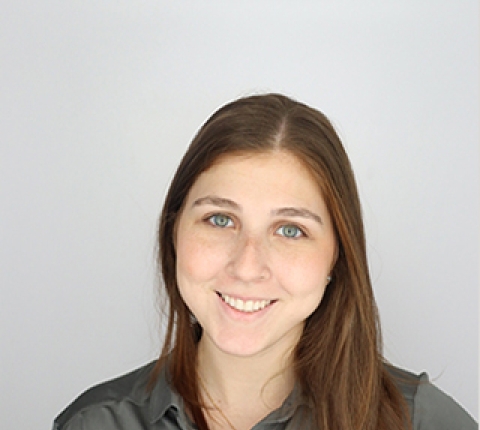 a young white woman with long, straight brown hair smiles at the camera